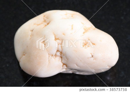 pebble of magnesite stone on dark background 38573738