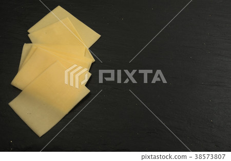 Sliced Cheese Over Stone Background Sliced Cheese Over Stone Background 38573807