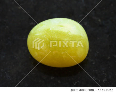 polished yellow calcite gemstone on dark 38574062