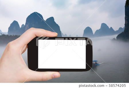 tourist photograps boats in fog in Yangshuo 38574205