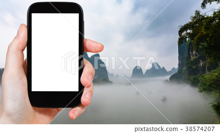 tourist photograps fog over river in Yangshuo 38574207