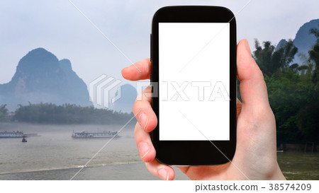 tourist photograps peaks and river in Yangshuo 38574209