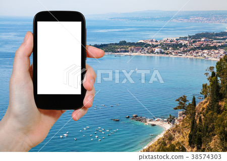 tourist photographs coastline with Giardini Naxos tourist photographs coastline with Giardini Naxos 38574303