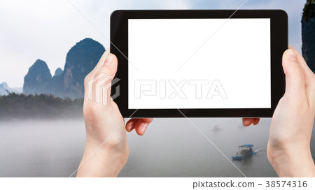 tourist photograps mist over river in Yangshuo 38574316