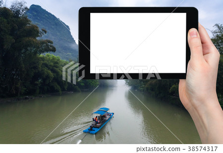 tourist photograps boat on river in Yangshuo 38574317
