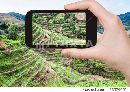 tourist photographs terraced slope with rice paddy 38574661