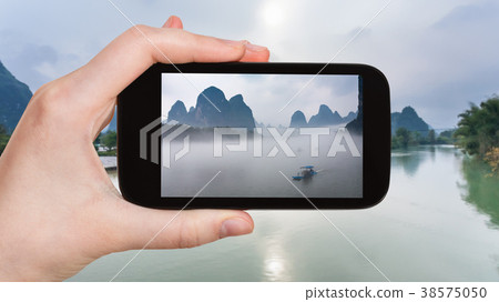 tourist photographs ships in fog on river in China 38575050