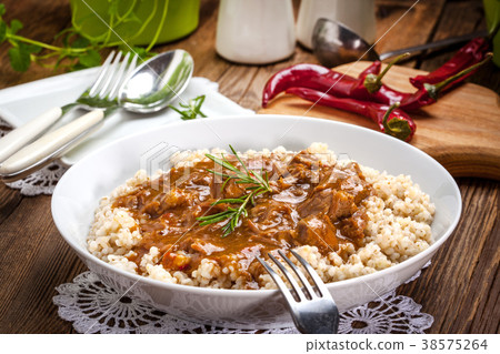 Cooked barley porridge and stew of pork. Cooked barley porridge and stew of pork. 38575264