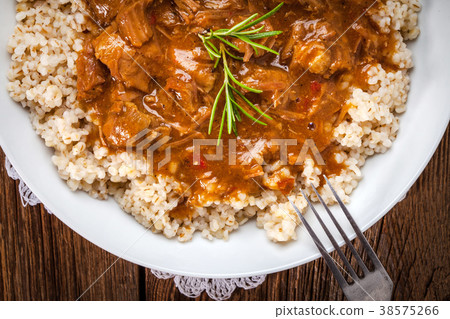 Cooked barley porridge and stew of pork. Cooked barley porridge and stew of pork. 38575266