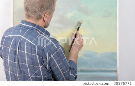 An artist painting in studio 38576771