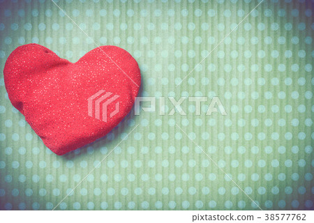 Colorful knitted hearts on a green background 38577762