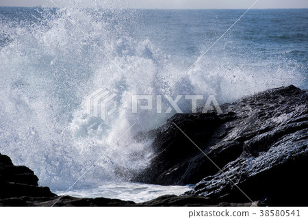 Rough waves crashing into rocks 38580541