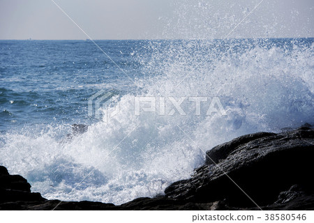 Rough waves crashing into rocks 38580546