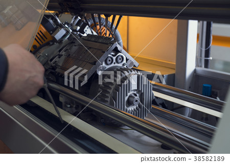 Serviceman setting up the machine at knitting shop Serviceman setting up the machine at knitting shop 38582189