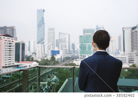 Businessman standing looking at Bangkok city view Businessman standing looking at Bangkok city view 38582402