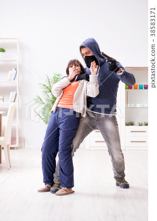 Armed man assaulting young woman at home 38583171