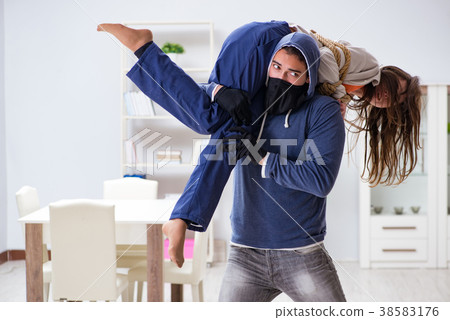 Armed man assaulting young woman at home Armed man assaulting young woman at home 38583176