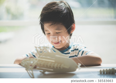 Asian child  builds a toy of wood 38583663