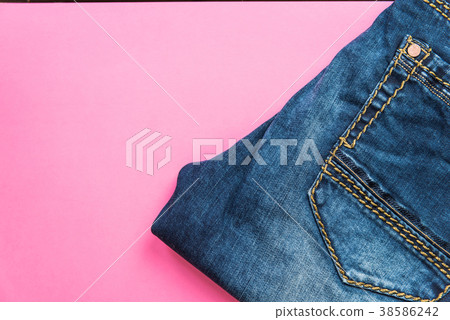 Blue jeans on pink pastel background Blue jeans on pink pastel background 38586242