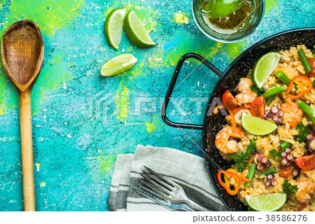 Serving healthy seafood spanish paella in pan Serving healthy seafood spanish paella in pan 38586276
