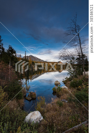 Autumn foliage reflection in alpine lake 38586521
