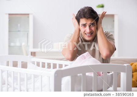 Young father dad frustrated at crying baby 38590163