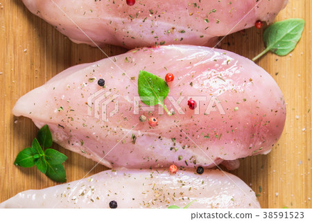 Raw chicken fillets on a cutting board Raw chicken fillets on a cutting board 38591523