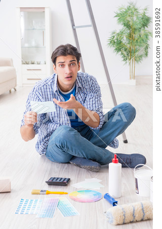 Young man overspending his budget in refurbishment Young man overspending his budget in refurbishment 38591692