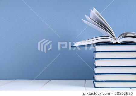 A stack of books on a blue background. A stack of books on a blue background. 38592650