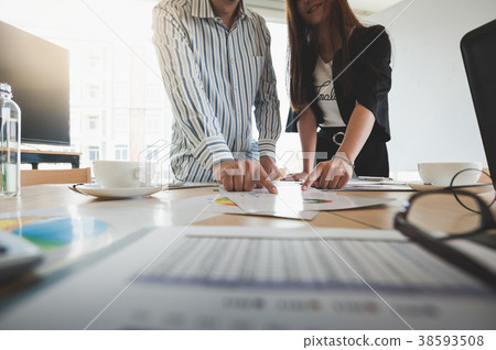 Businesspeople poiting at document on table Businesspeople poiting at document on table 38593508