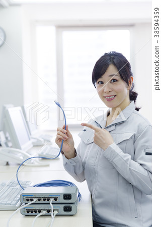 Woman in work clothes with LAN cable 38594359