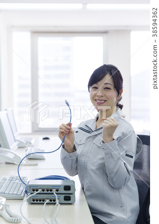 Woman in work clothes with LAN cable 38594362