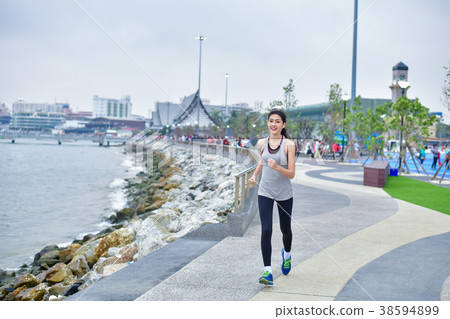 Sports concept. Beautiful girl is exercising on the beach with r Sports concept. Beautiful girl is exercising on the beach with r 38594899