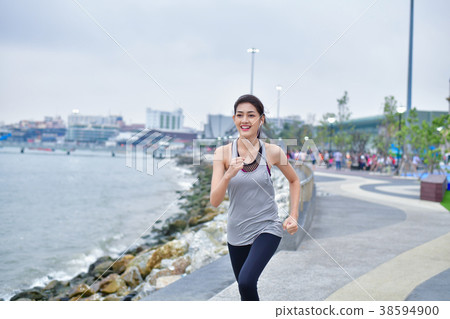 Sports concept. Beautiful girl is exercising on the beach with r 38594900