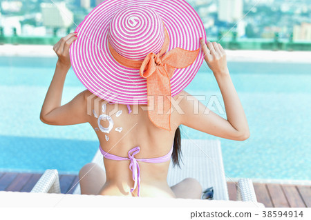 Swimsuit Concept. Beautiful girl in swimsuit is applying sunscre 38594914