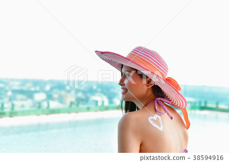 Swimsuit Concept. Beautiful girl in swimsuit is applying sunscre Swimsuit Concept. Beautiful girl in swimsuit is applying sunscre 38594916