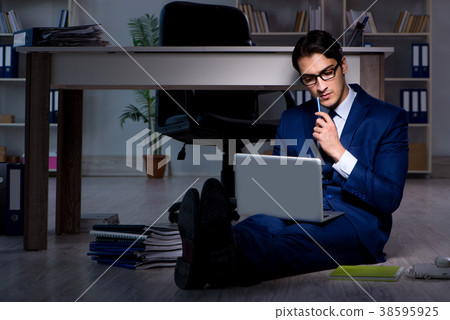 Businessman working overtime long hours late in 38595925