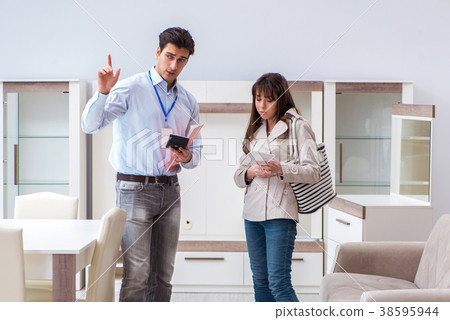 Salesman explaining to woman customer at furniture 38595944