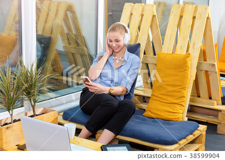 Pretty businesswoman is listening to music in Pretty businesswoman is listening to music in 38599904