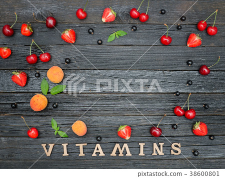 Inscription Vitamins and fruits. Black background Inscription Vitamins and fruits. Black background 38600801