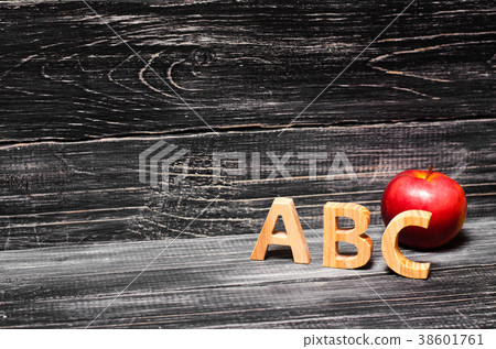 Alphabet letters and apple on a black background.  38601761