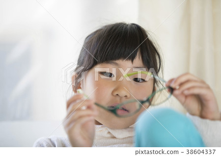 Child checking dirt on glasses 38604337