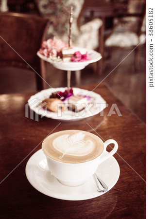 White cup with latte coffee and cake 38605182