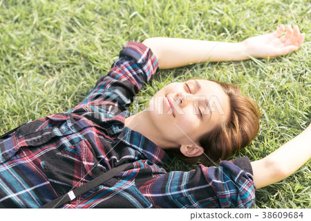 Woman lying on the grass (relaxed image) Woman lying on the grass (relaxed image) 38609684