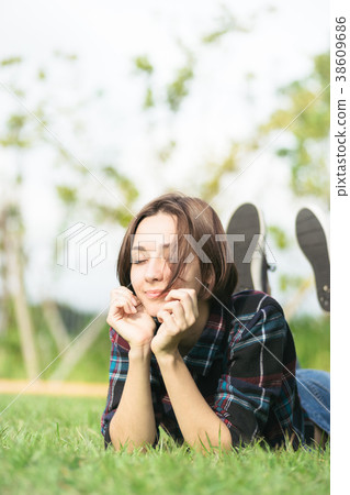 Woman lying on the grass (relaxed image) Woman lying on the grass (relaxed image) 38609686