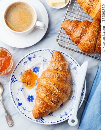 Croissant with coffee, jam and butter. Top view 38609839