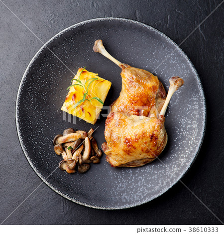 Duck legs confit, potato gratin and mushroom sauce Duck legs confit, potato gratin and mushroom sauce 38610333