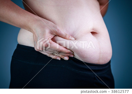 Woman checking fat on abdomen. Overweight concept Woman checking fat on abdomen. Overweight concept 38612577