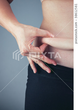 Woman checking fat on abdomen. Overweight concept Woman checking fat on abdomen. Overweight concept 38612581