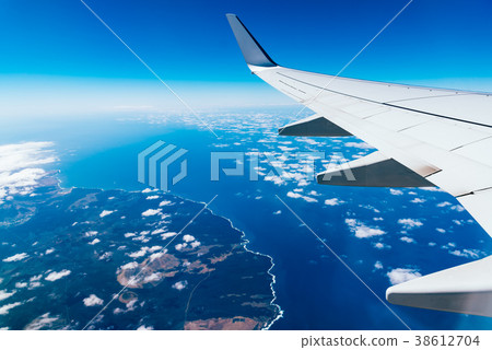 Wing of airplane above island 38612704